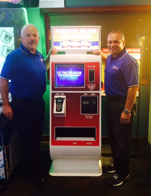 Debit card system fans Chuck Peitz (left) and Joe Ingui of Tricorp Amusements with an Embed system kiosk.