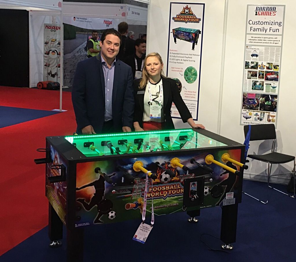 Gregory and Anna Bacorn behind Barron Games' World Tour Foosball table at IAAPA's EAS show in September.