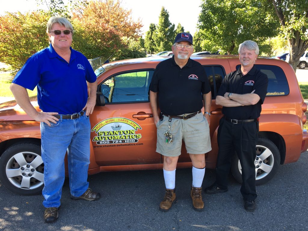 Out on the job, and boasting an incredible 126 years of experience in the business among them, are (from left): Bill Banks (who as an operator bought his first machine in 1976), Richie Robinson (who started out in 1972 at Binghamton’s Standard Vending) & Rick Reisbeck (who began with Joy Automatics back in 1974). The company logo on the door says Stanton provides pool, music, darts as well as ATMs.