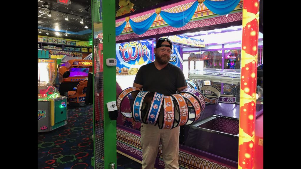 Clarence Mabe location image - player with arms full of prize rings