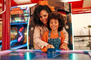 Mom and Daughter playing air hockey - Party Professor 0626 - Adobe Stock